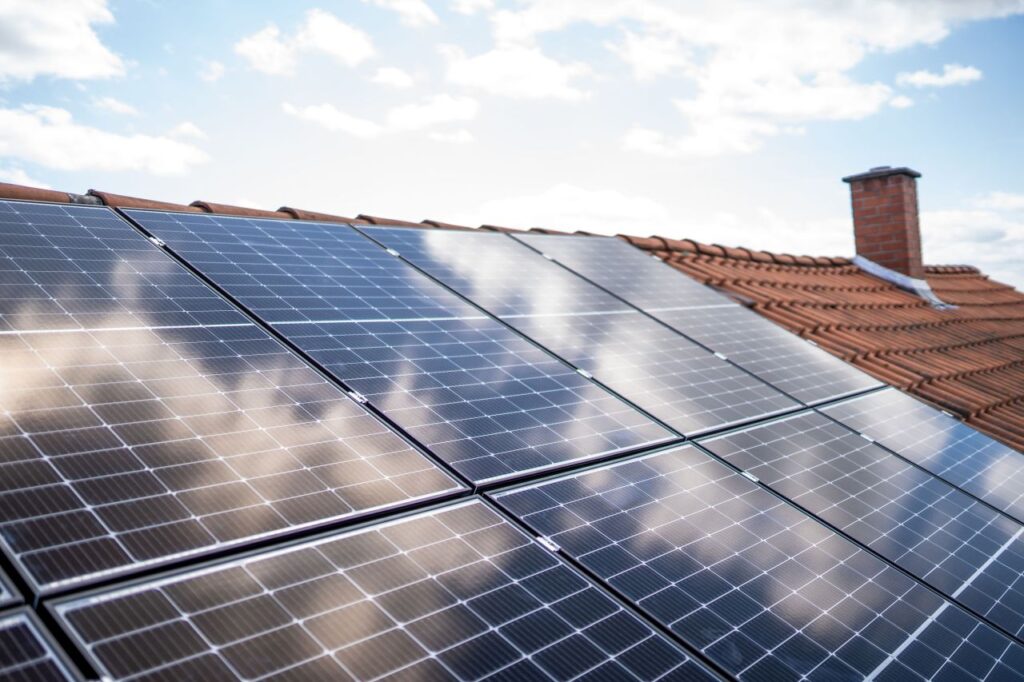 Ein Haus mit Sonnenkollektoren auf dem Dach, ausgestattet mit einer Photovoltaikanlage.