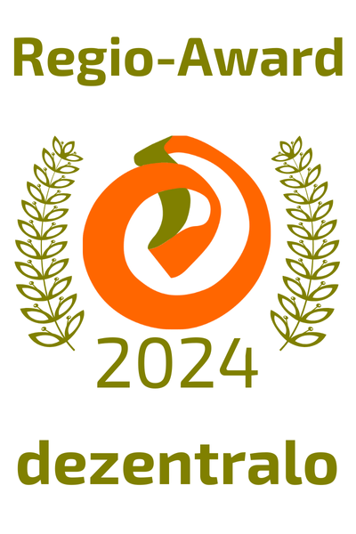 Regio-Award-Logo: Orangefarbenes Emblem mit grünem Akzent, flankiert von zwei Olivenzweigen. Der Text lautet „Regio-Award 2024 dezentralo“.